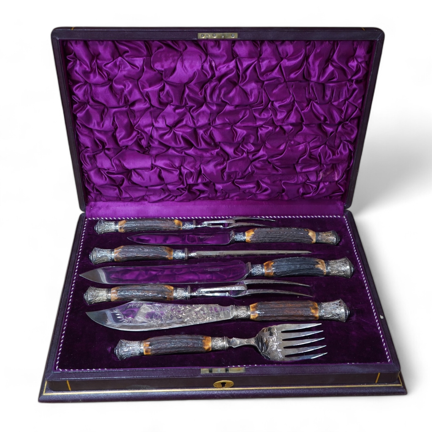 A gilt tooled leather cased stag handled silver collared carving set, case 44cm wide. Condition - good